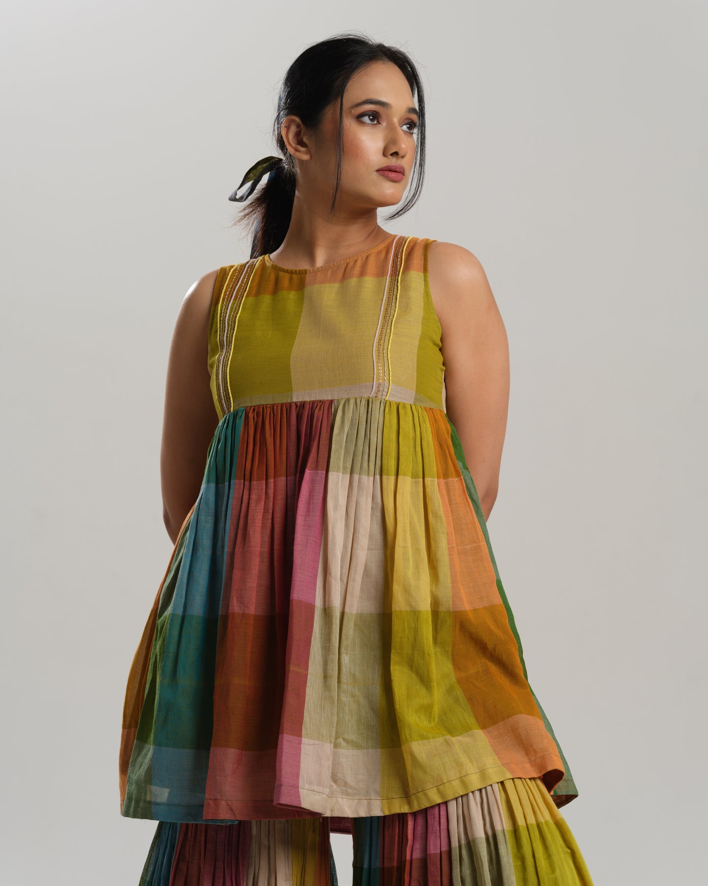 Model wearing a handwoven Narayanpet cotton sharara set in vibrant multicolour checks with embroidery detailing.