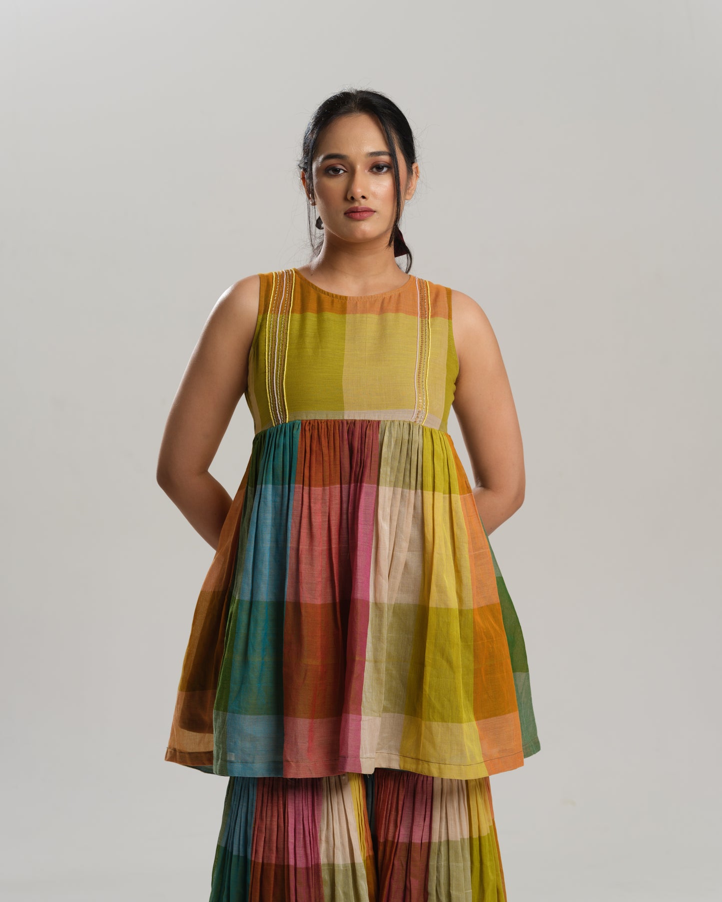Model wearing a handwoven Narayanpet cotton sharara set in vibrant multicolour checks with embroidery detailing.