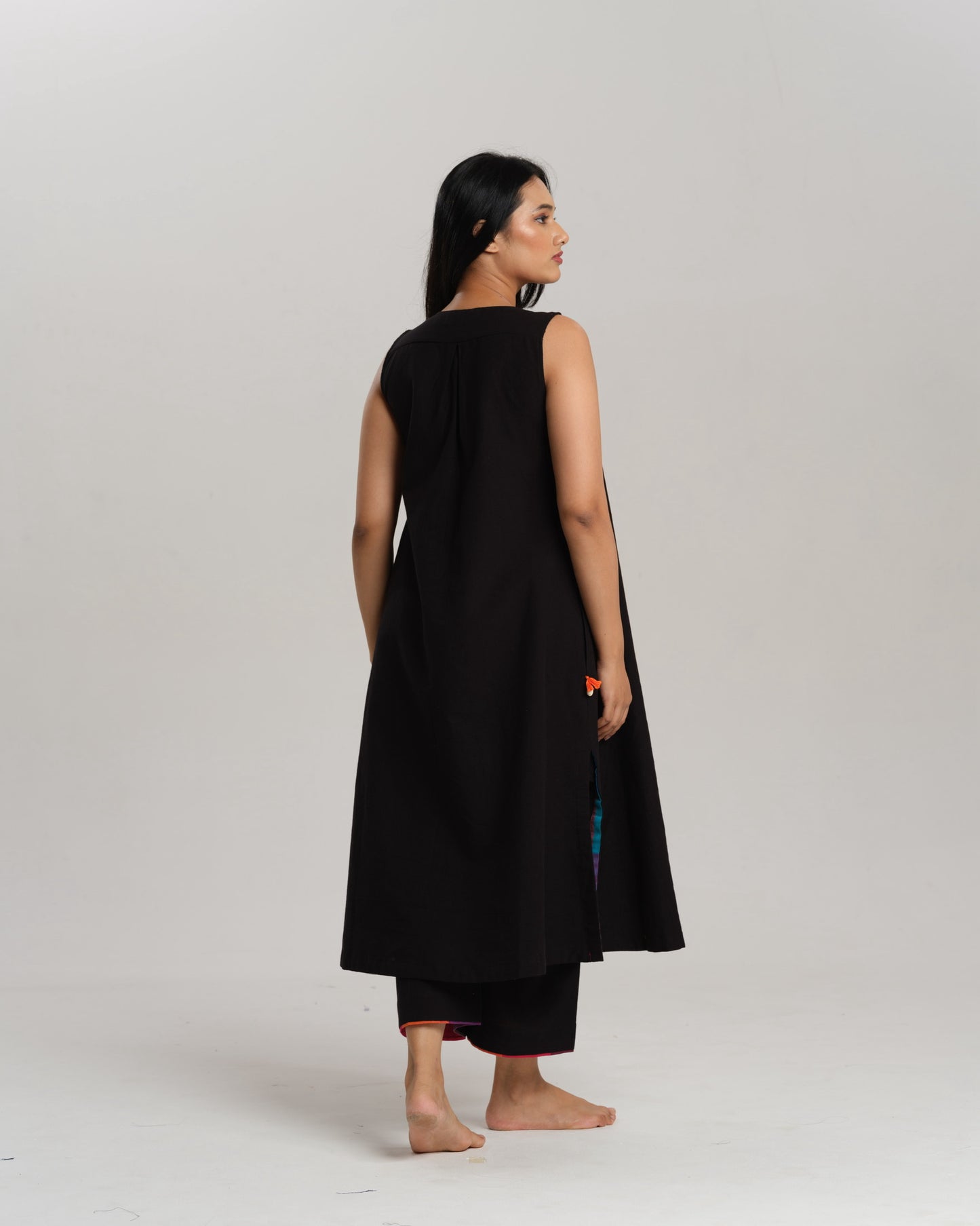 Model wearing Charcoal Charm – Ikat Kurta Set by Taram, black cotton kurta with patchwork, pants and vibrant South checks stole.