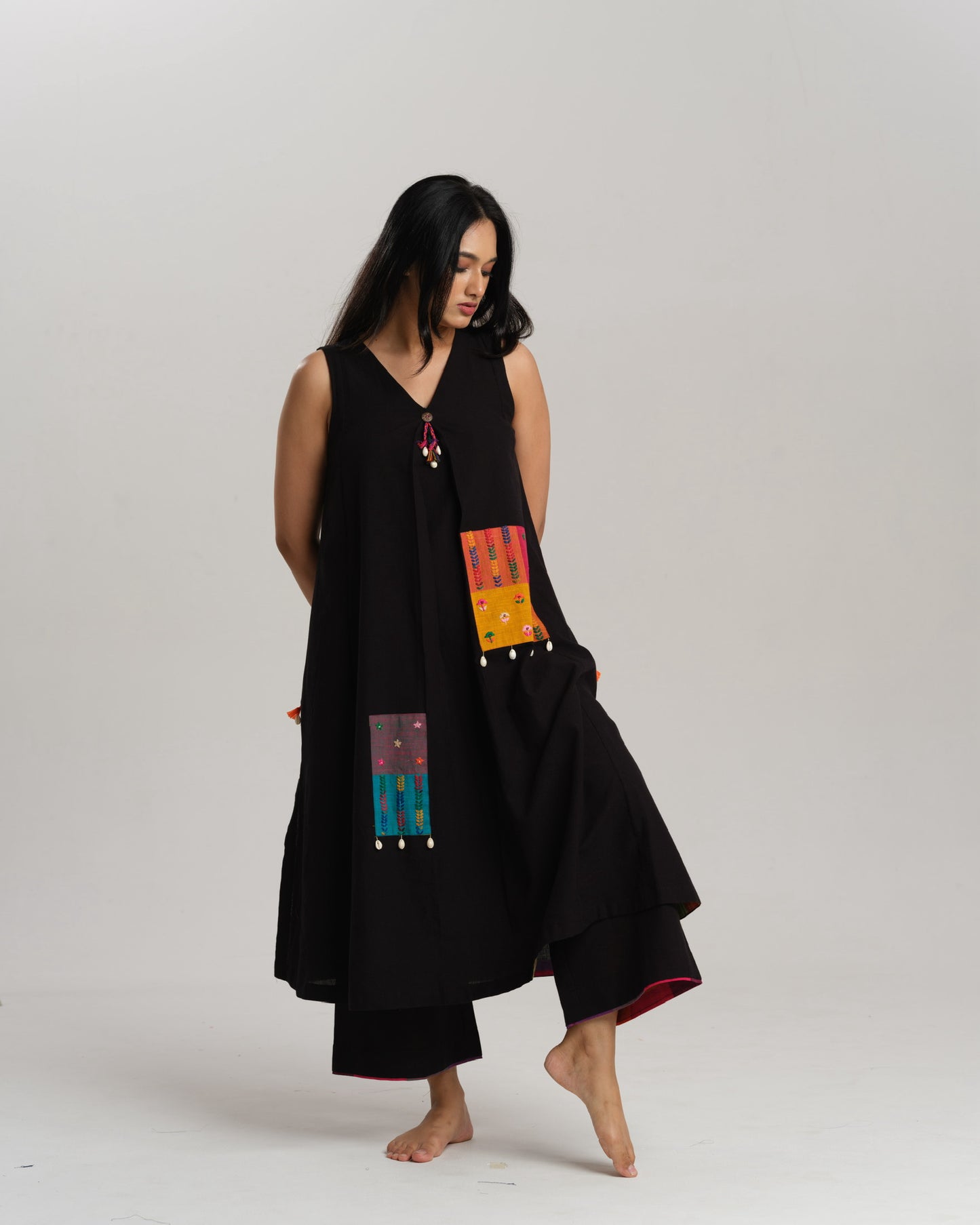 Model wearing Charcoal Charm – Ikat Kurta Set by Taram, black cotton kurta with patchwork, pants and vibrant South checks stole.