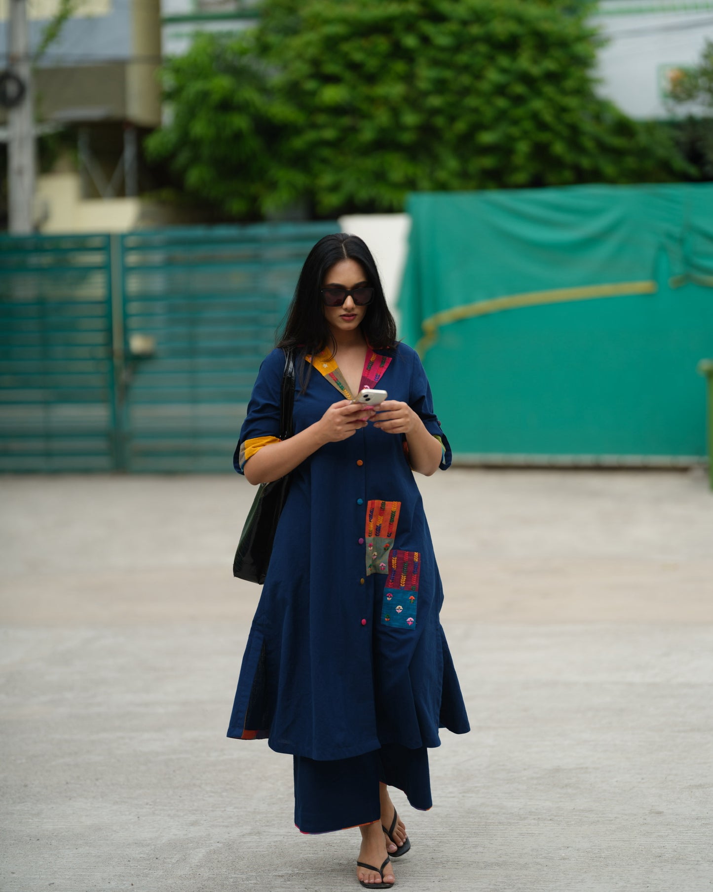 Woman wearing an indigo Ikat kurta with multicolour patch pocket and collar, standing against a neutral background.