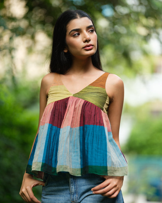 Woman wearing a handwoven Narayanpet sleeveless top with colourblocked panels, standing outdoors in natural light.