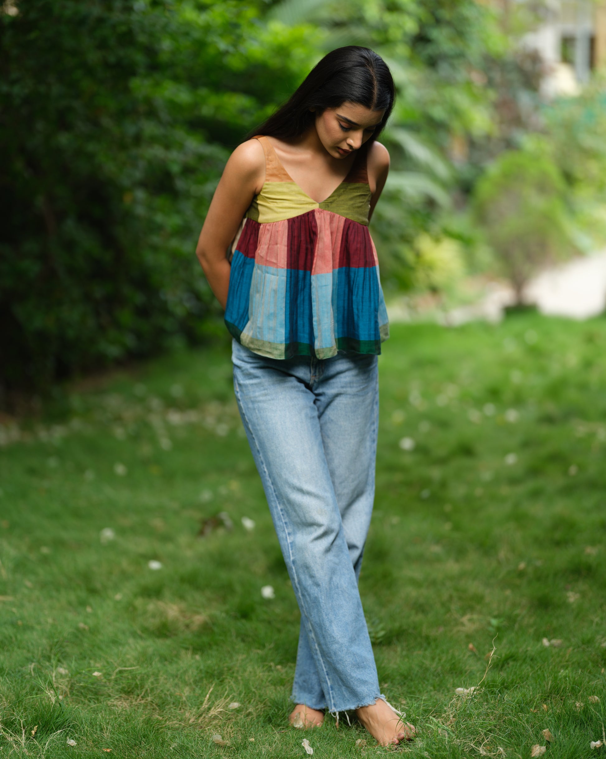 Woman wearing a handwoven Narayanpet sleeveless top with colourblocked panels, standing outdoors in natural light.