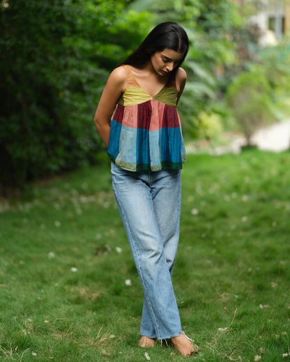 Woman wearing a handwoven Narayanpet sleeveless top with colourblocked panels, standing outdoors in natural light.