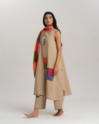 Model wearing beige sleeveless handwoven Ikat kurta set with patchwork in South Indian checks, paired with matching pants and colorful stole – Ikat Rhythm by Taram.