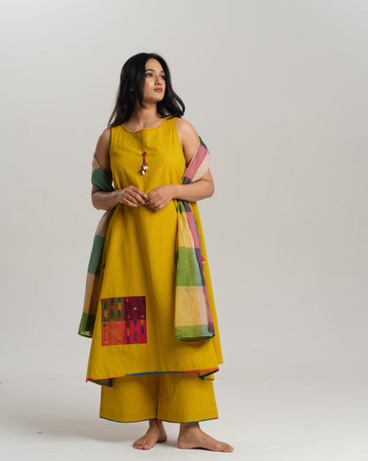 Model in mustard handwoven Ikat kurta set with patchwork pockets, wide pants, and a multi-color stole—Taram’s Sunkissed Loom with artisanal styling.