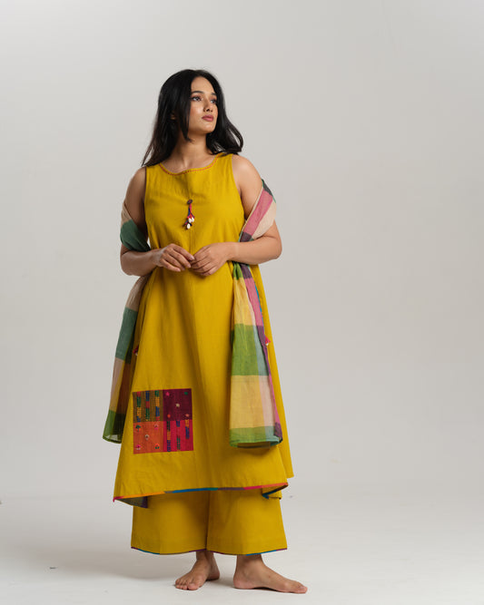 Model in mustard handwoven Ikat kurta set with patchwork pockets, wide pants, and a multi-color stole—Taram’s Sunkissed Loom with artisanal styling.