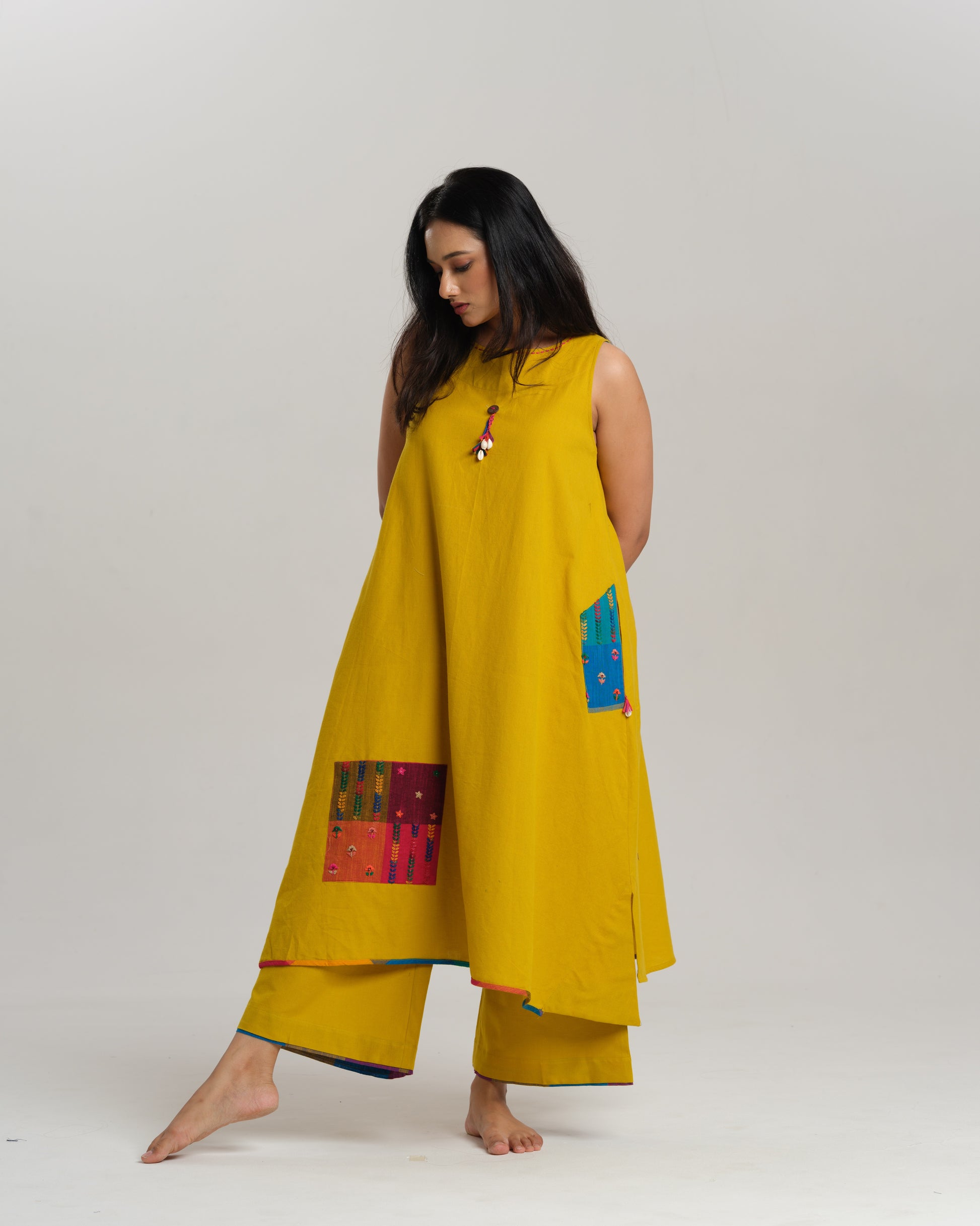 Model in mustard handwoven Ikat kurta set with patchwork pockets, wide pants, and a multi-color stole—Taram’s Sunkissed Loom with artisanal styling