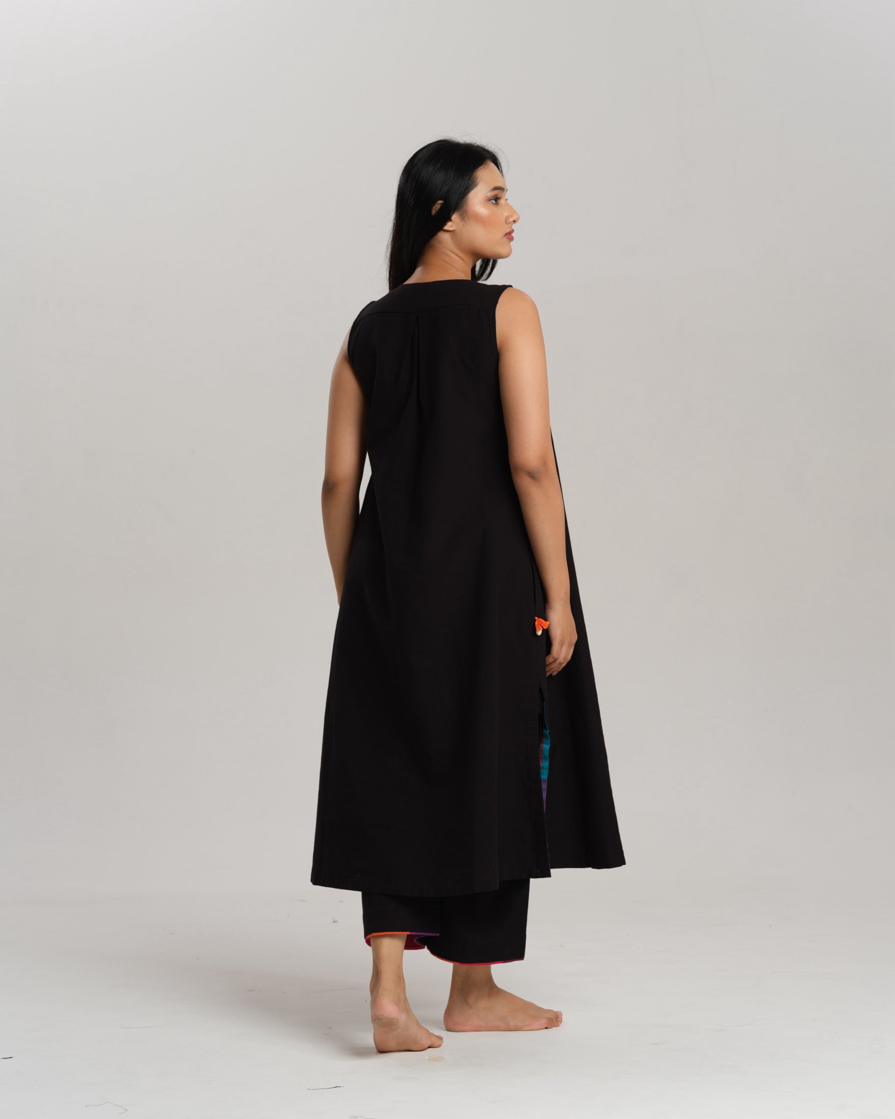 Model wearing Charcoal Charm – Ikat Kurta Set by Taram, black cotton kurta with patchwork, pants and vibrant South checks stole.
