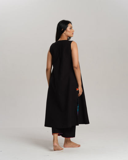 Model wearing Charcoal Charm – Ikat Kurta Set by Taram, black cotton kurta with patchwork, pants and vibrant South checks stole.