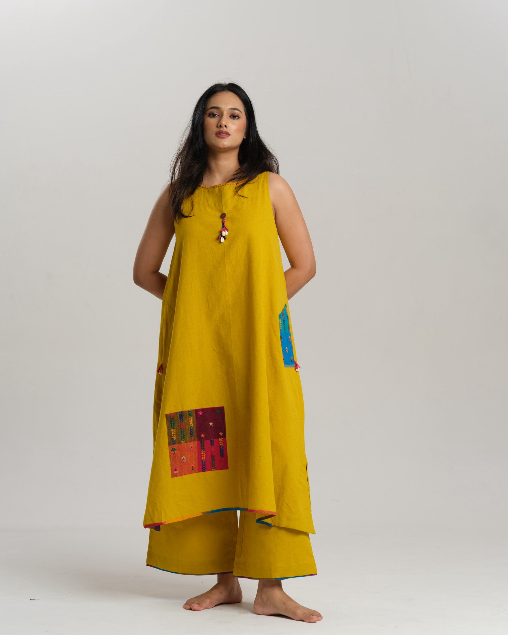 Model in mustard handwoven Ikat kurta set with patchwork pockets, wide pants, and a multi-color stole—Taram’s Sunkissed Loom with artisanal styling