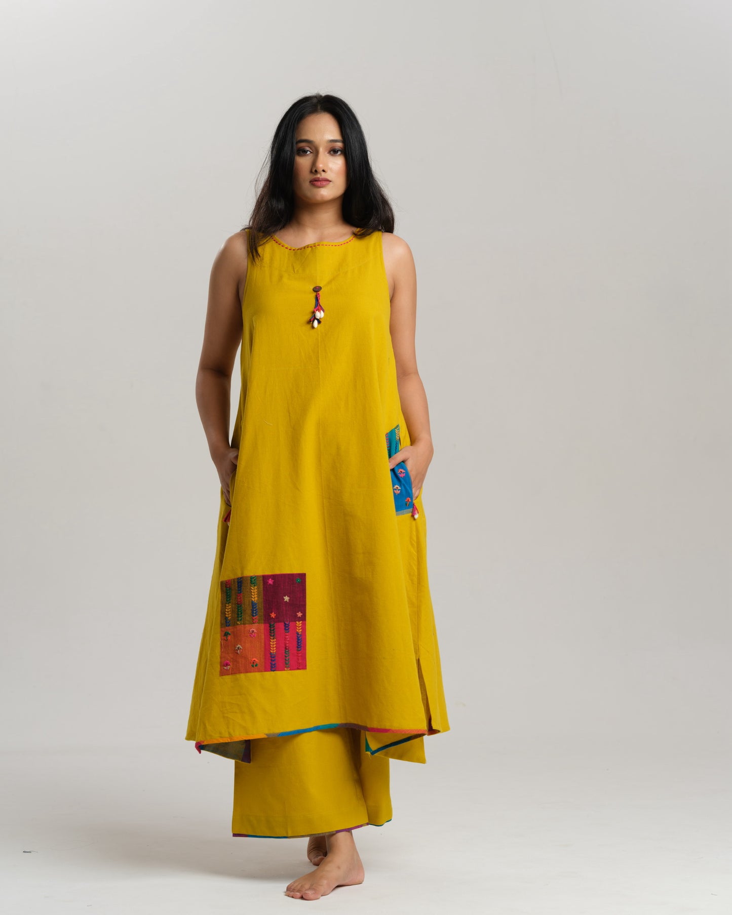 Model in mustard handwoven Ikat kurta set with patchwork pockets, wide pants, and a multi-color stole—Taram’s Sunkissed Loom with artisanal styling.