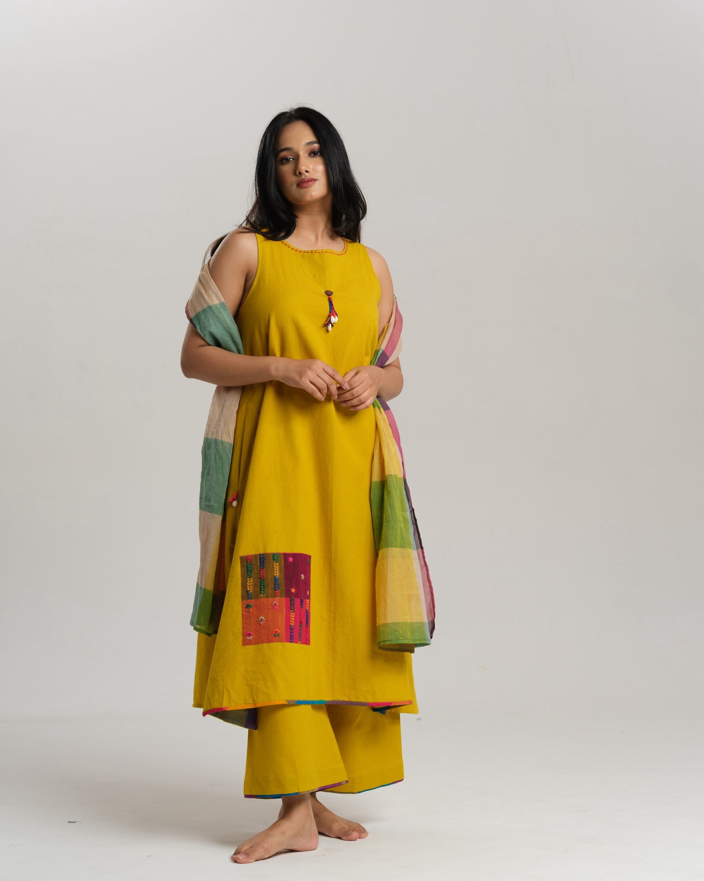 Model in mustard handwoven Ikat kurta set with patchwork pockets, wide pants, and a multi-color stole—Taram’s Sunkissed Loom with artisanal styling.