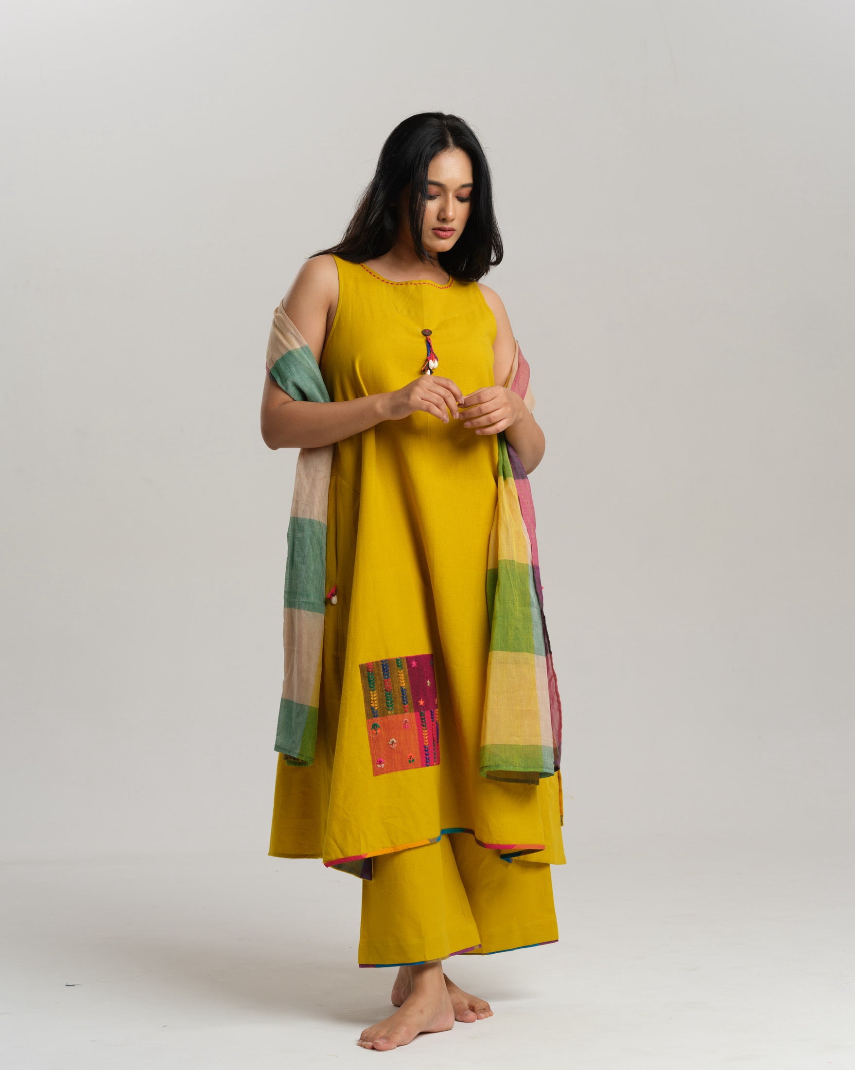 Model in mustard handwoven Ikat kurta set with patchwork pockets, wide pants, and a multi-color stole—Taram’s Sunkissed Loom with artisanal styling