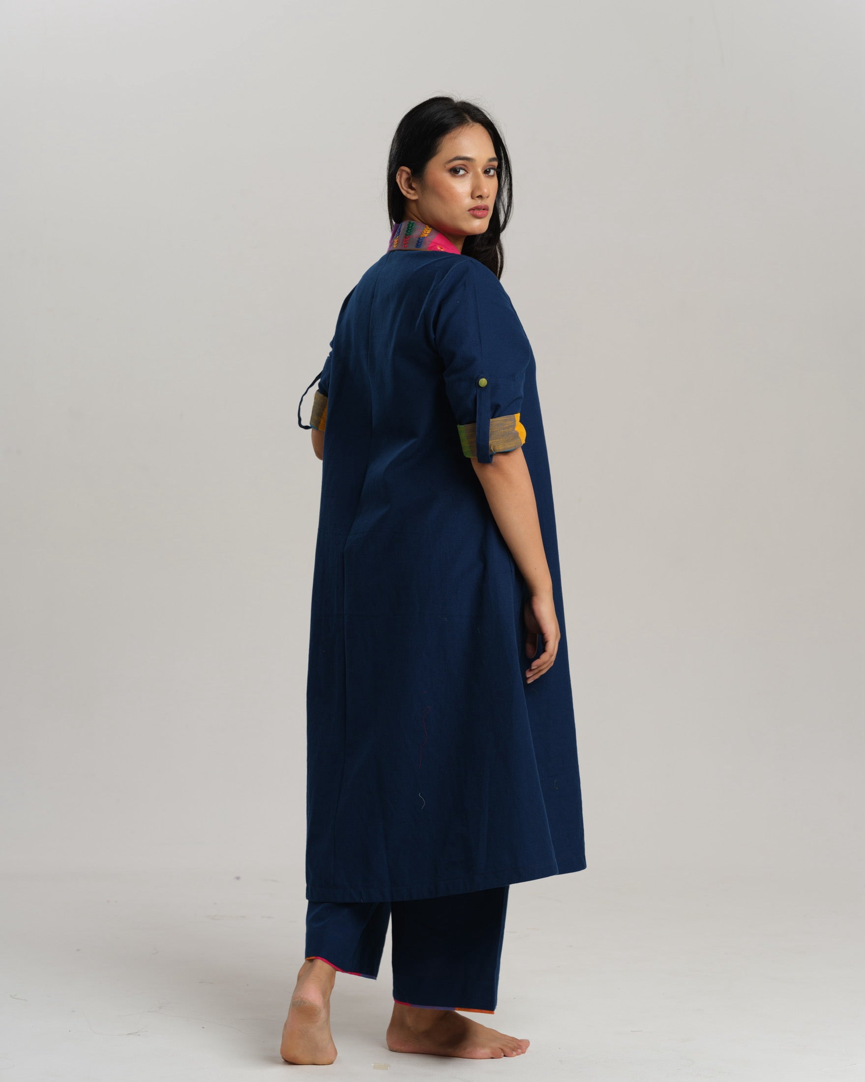 Woman wearing an indigo Ikat kurta with multicolour patch pocket and collar, standing against a neutral background.