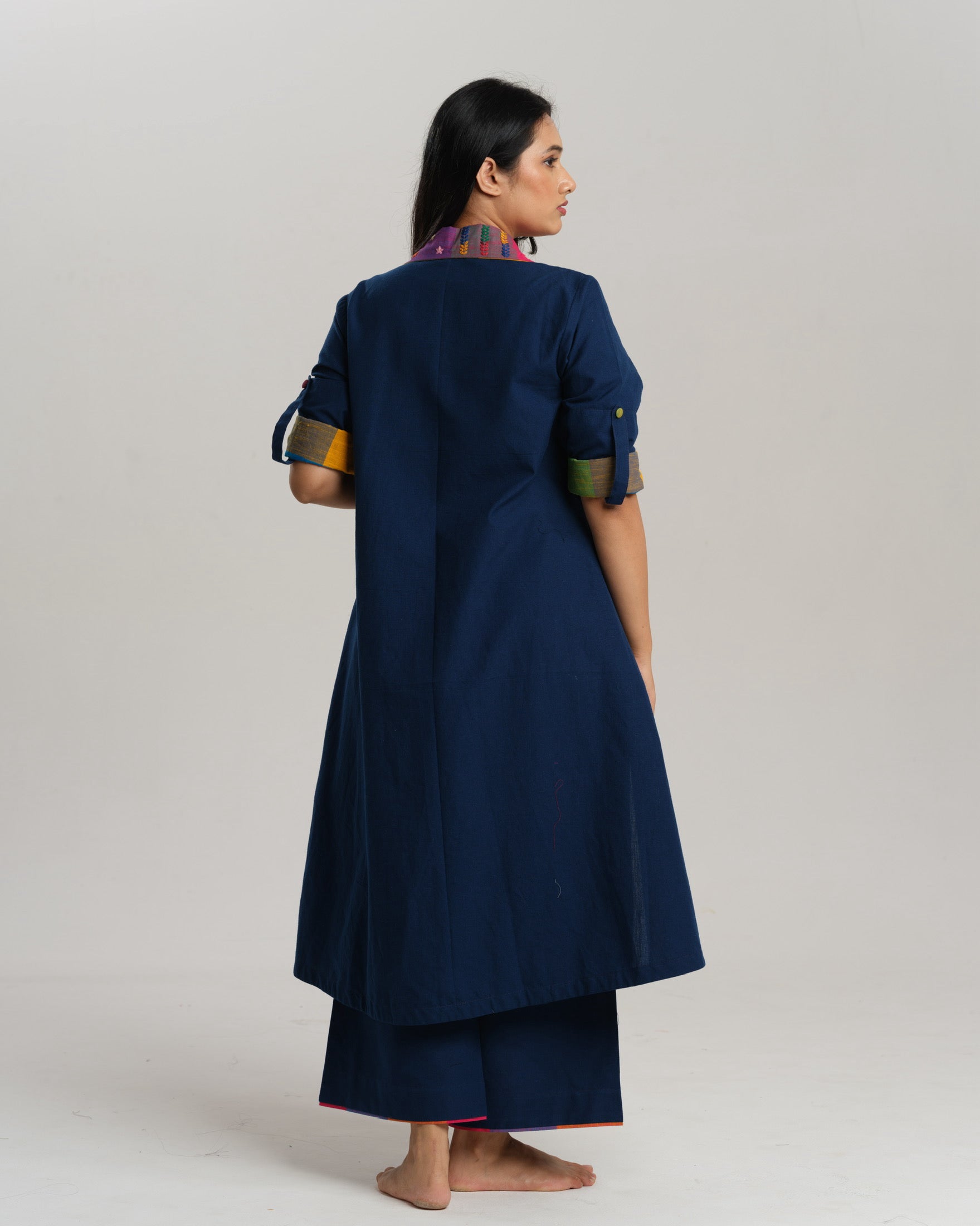 Woman wearing an indigo Ikat kurta with multicolour patch pocket and collar, standing against a neutral background.