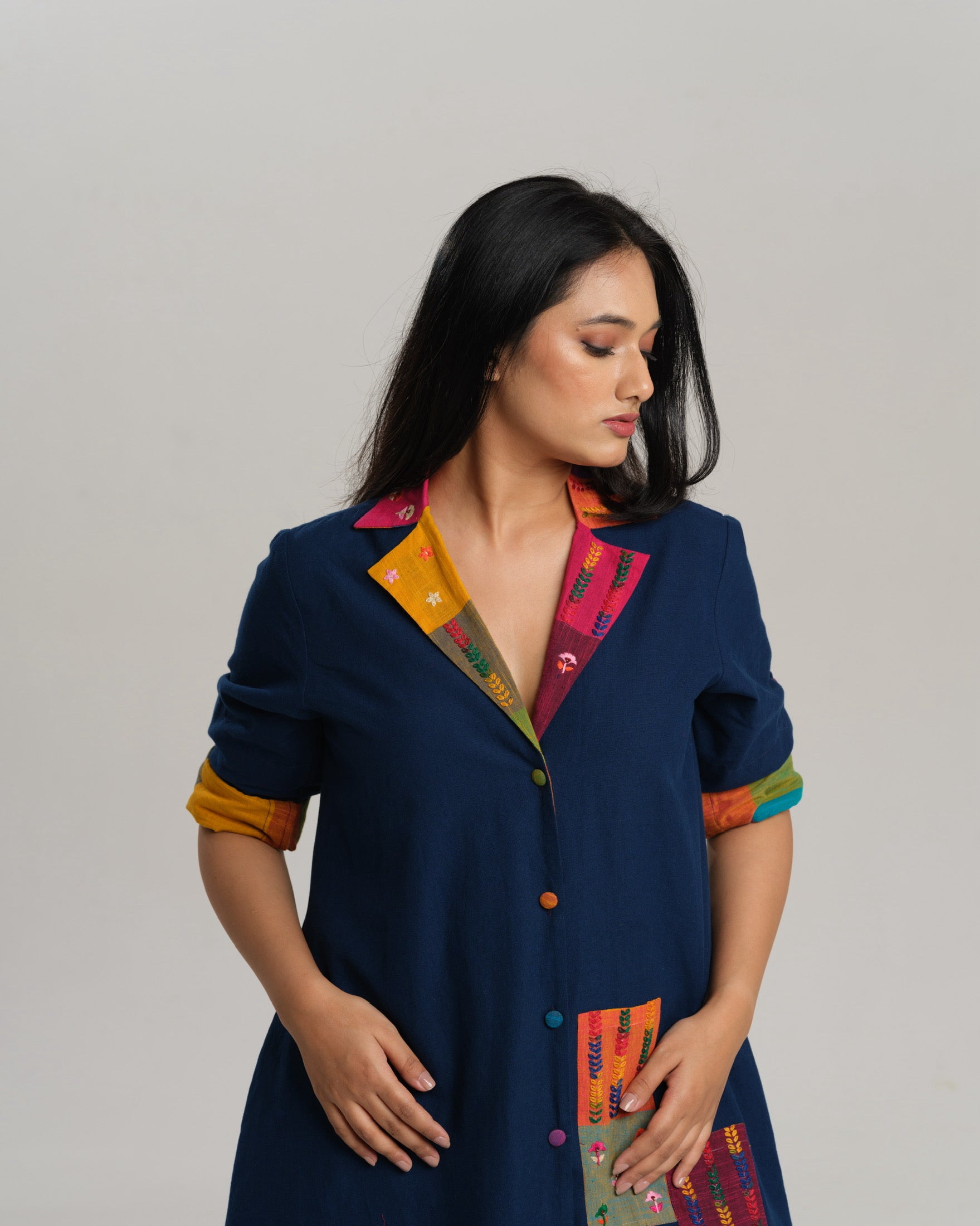 Woman wearing an indigo Ikat kurta with multicolour patch pocket and collar, standing against a neutral background.