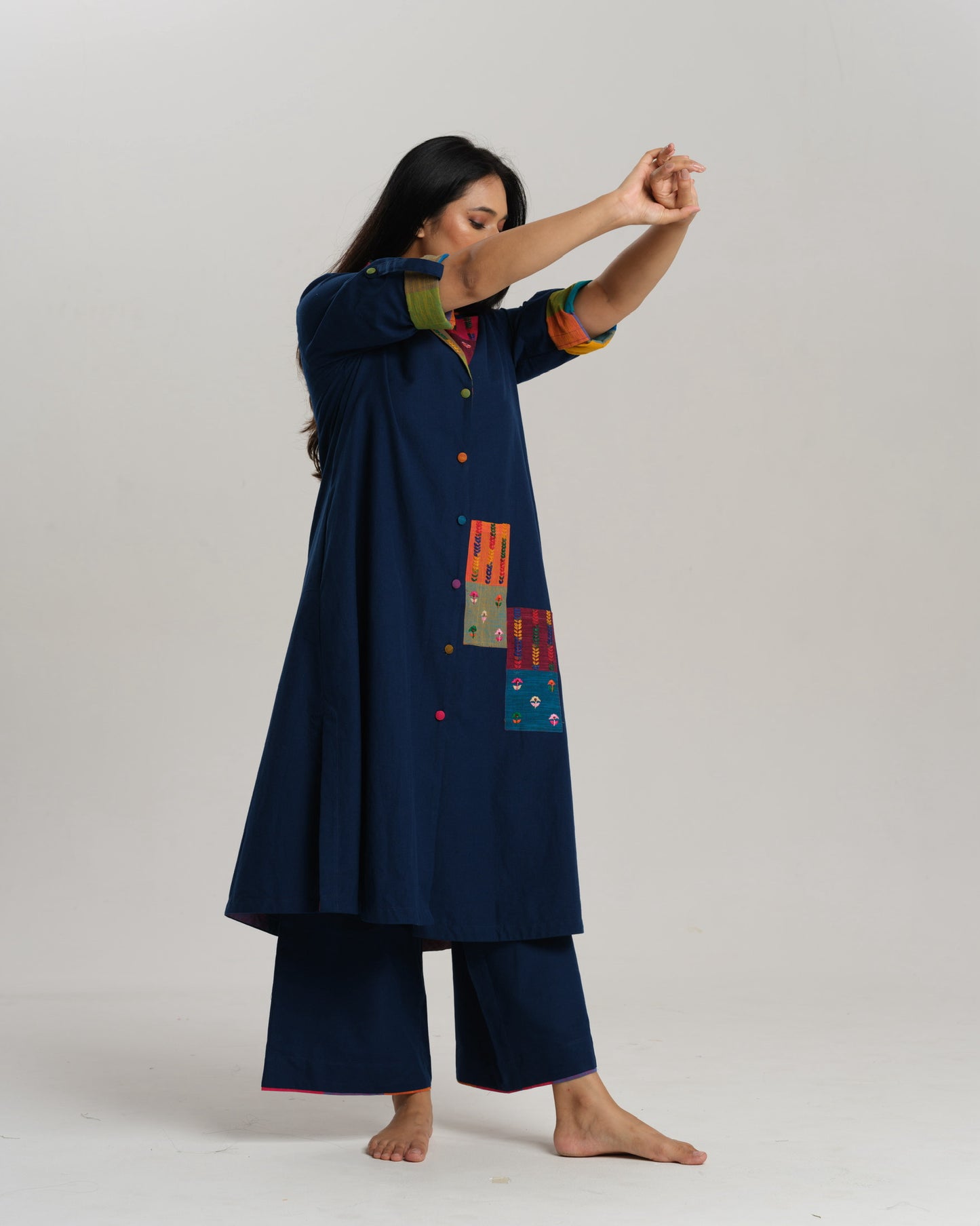 Woman wearing an indigo Ikat kurta with multicolour patch pocket and collar, standing against a neutral background.
