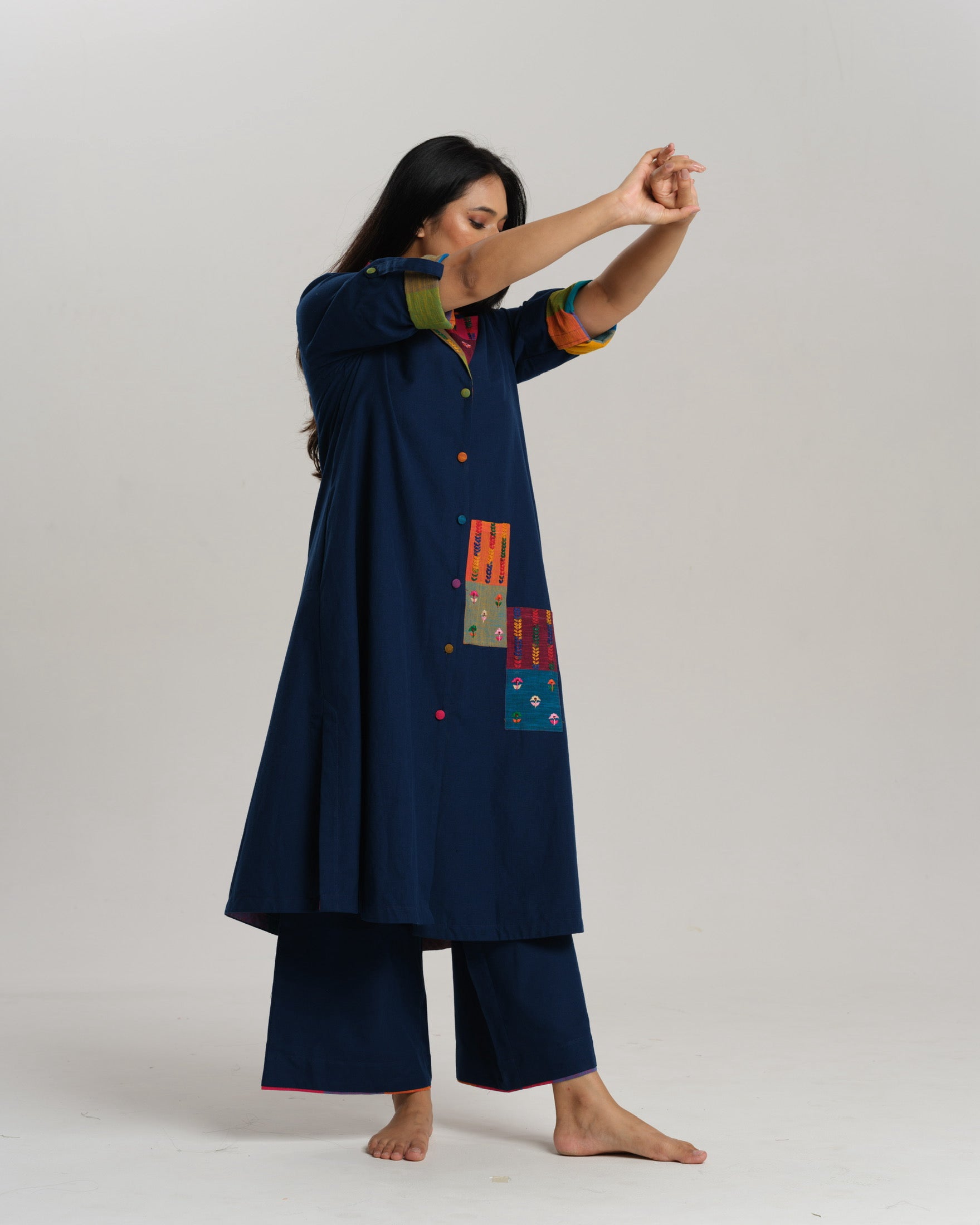 Woman wearing an indigo Ikat kurta with multicolour patch pocket and collar, standing against a neutral background.