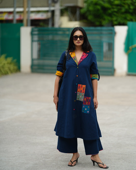 Woman wearing an indigo Ikat kurta with multicolour patch pocket and collar, standing against a neutral background.