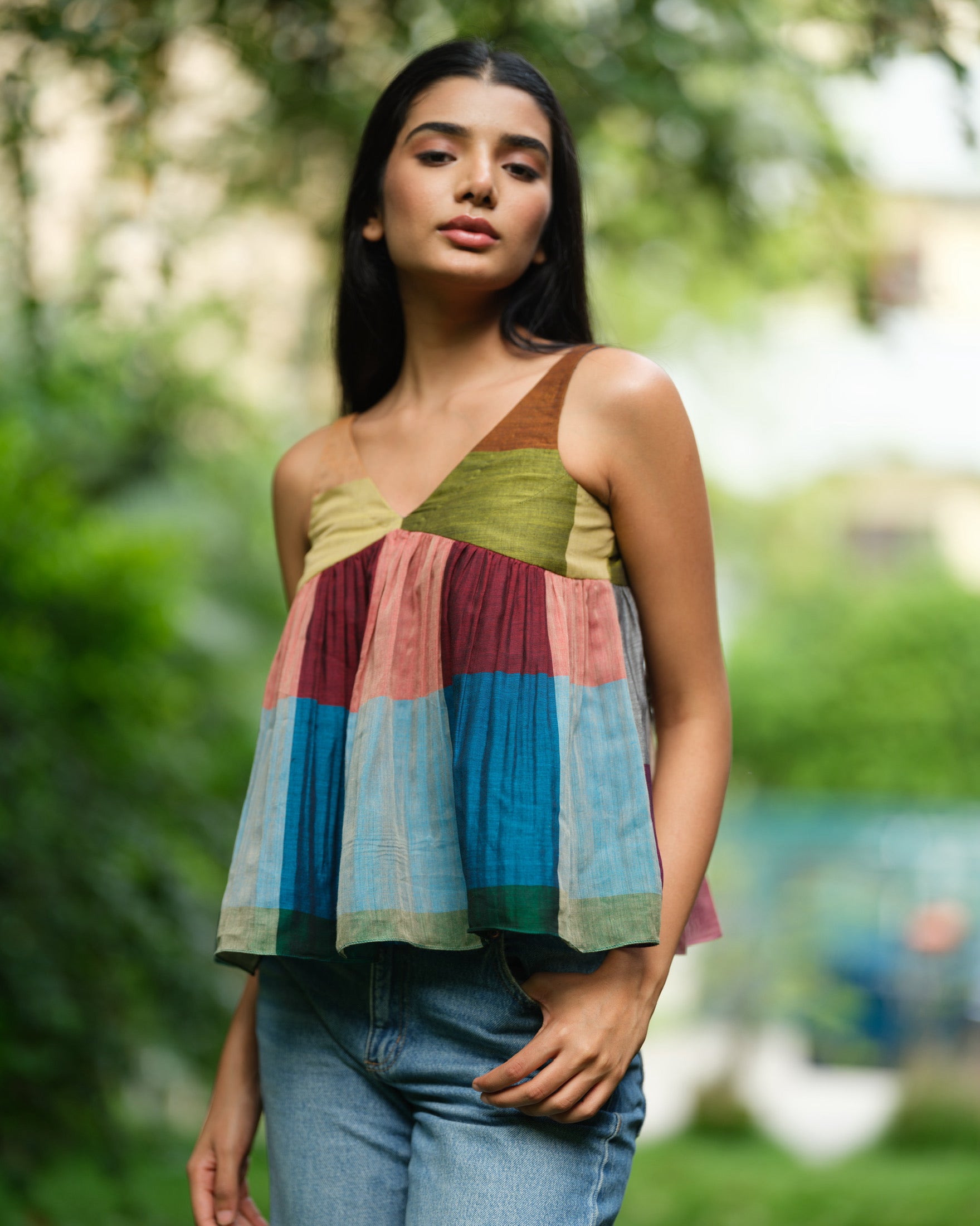 Woman wearing a handwoven Narayanpet sleeveless top with colourblocked panels, standing outdoors in natural light.