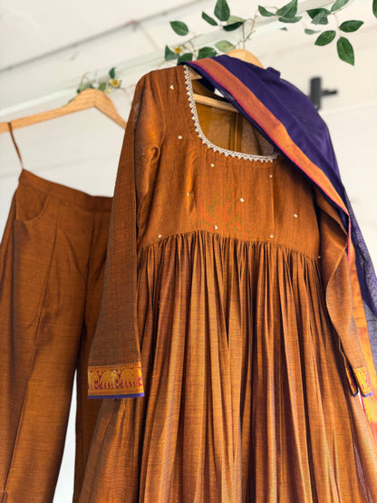 Shop The Copper Crown Kurtha Set at The Taram. A rich copper-toned handloom kurtha set with traditional zari borders, crafted for timeless elegance and festive wear.