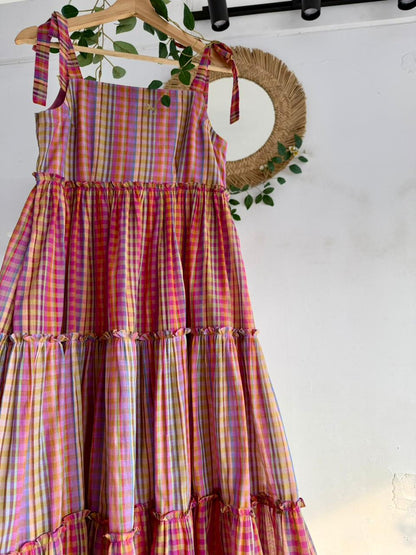 Candy Cloud Multi-Tiered Dress – pastel multicolor checked handloom dress with tie-up straps and tiered silhouette displayed on hanger.