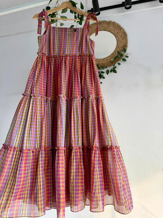 Candy Cloud Multi-Tiered Dress – pastel multicolor checked handloom dress with tie-up straps and tiered silhouette displayed on hanger.
