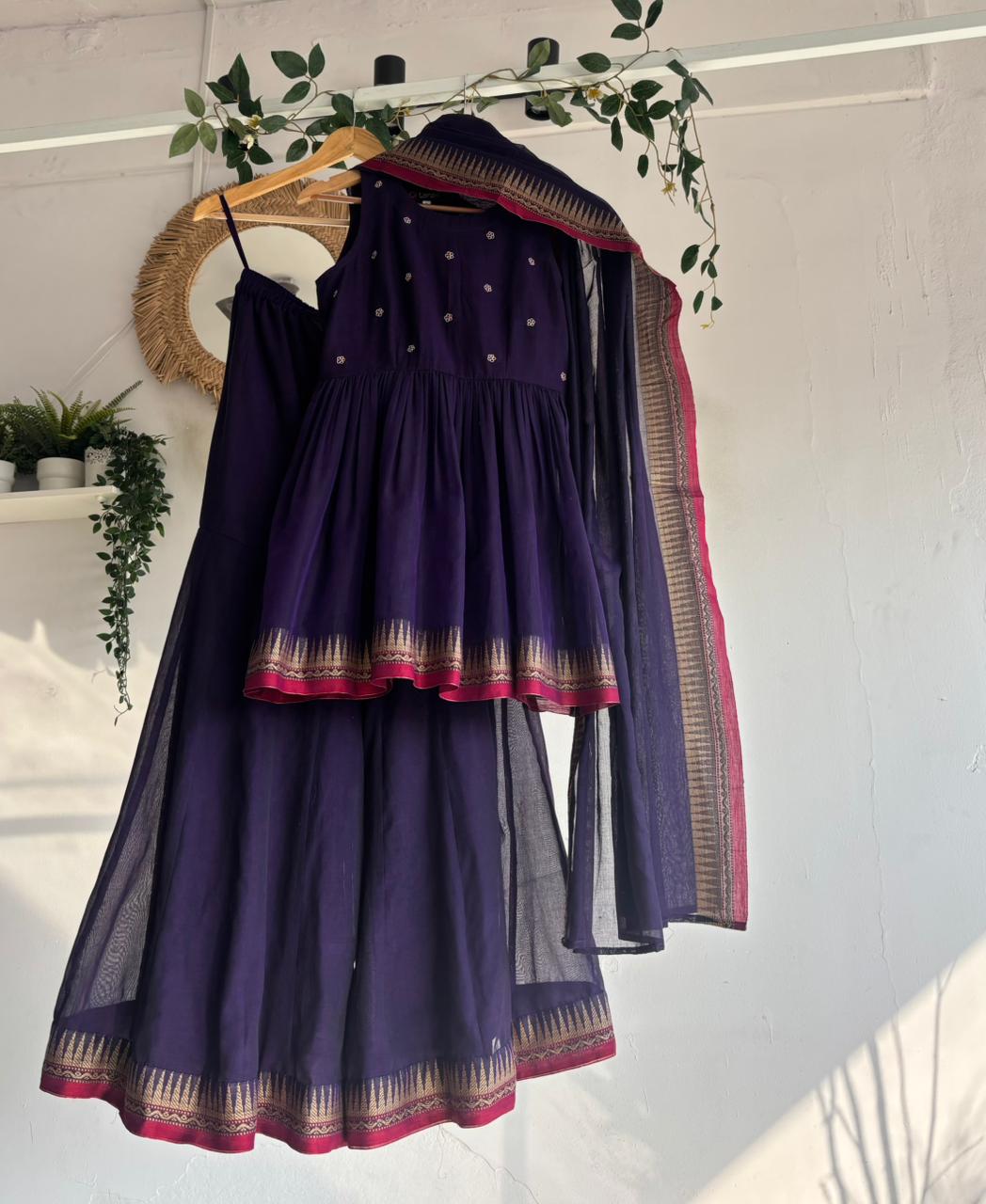 Purple Narayanpet Sharara Set – handloom purple kurta with gold motifs, flared sharara, and matching dupatta with zari border displayed on hanger.