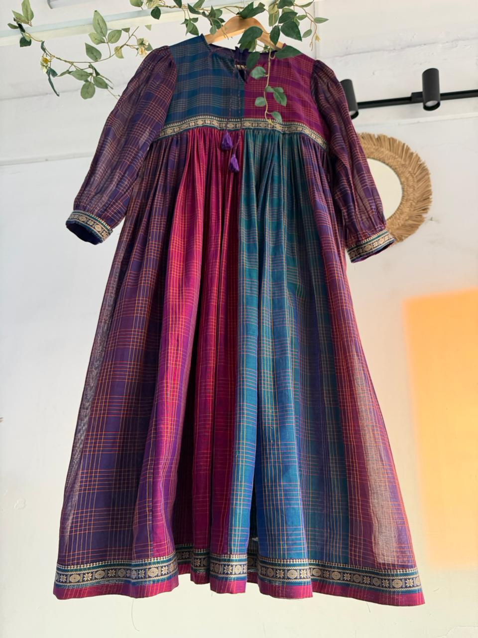 Queen’s Palette Narayanpet Dress – multi-hued handloom cotton dress in purple, magenta, and teal with zari borders, displayed on hanger.